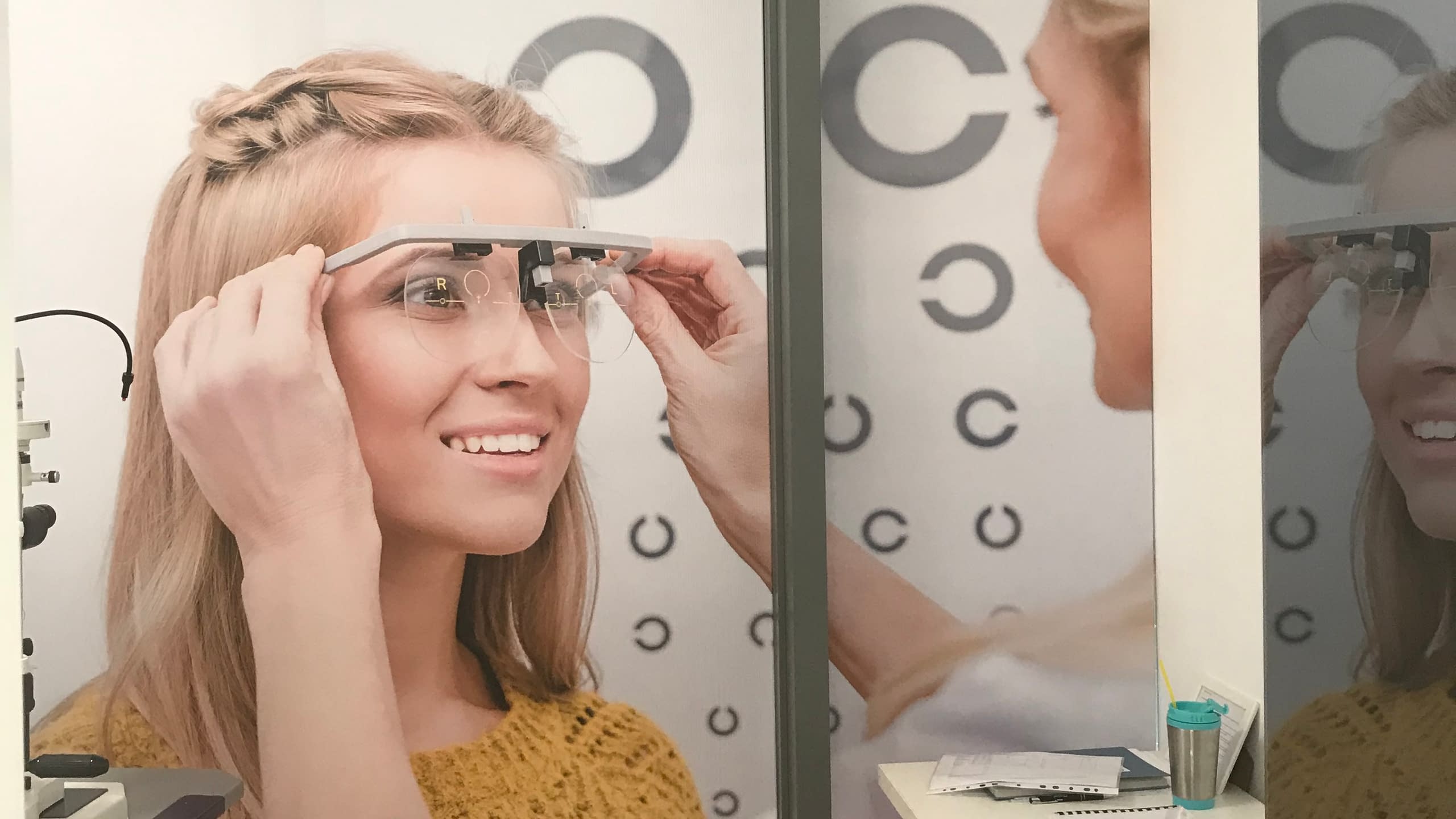 Фототапет по поръчка за оптика или лекарски кабинет, изобразяващ жена по време на очен преглед.