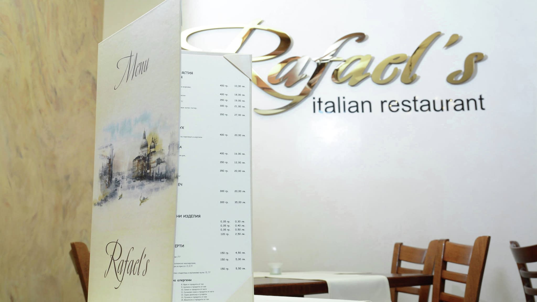 Меню и златиста интериорна табела с надпис Rafael's Italian Restaurant в елегантен интериор на италиански ресторант.