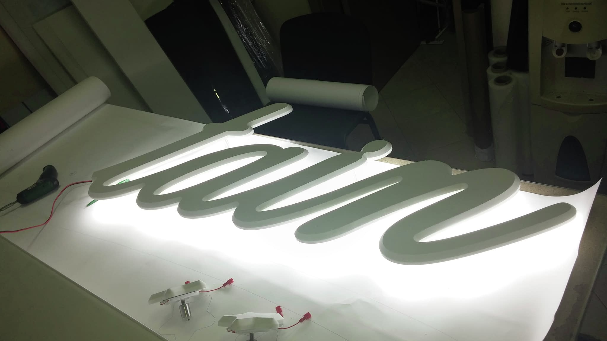 Светеща обемна табела с надпис 'tain' в курсивен стил, подготвена за монтаж с LED осветление.