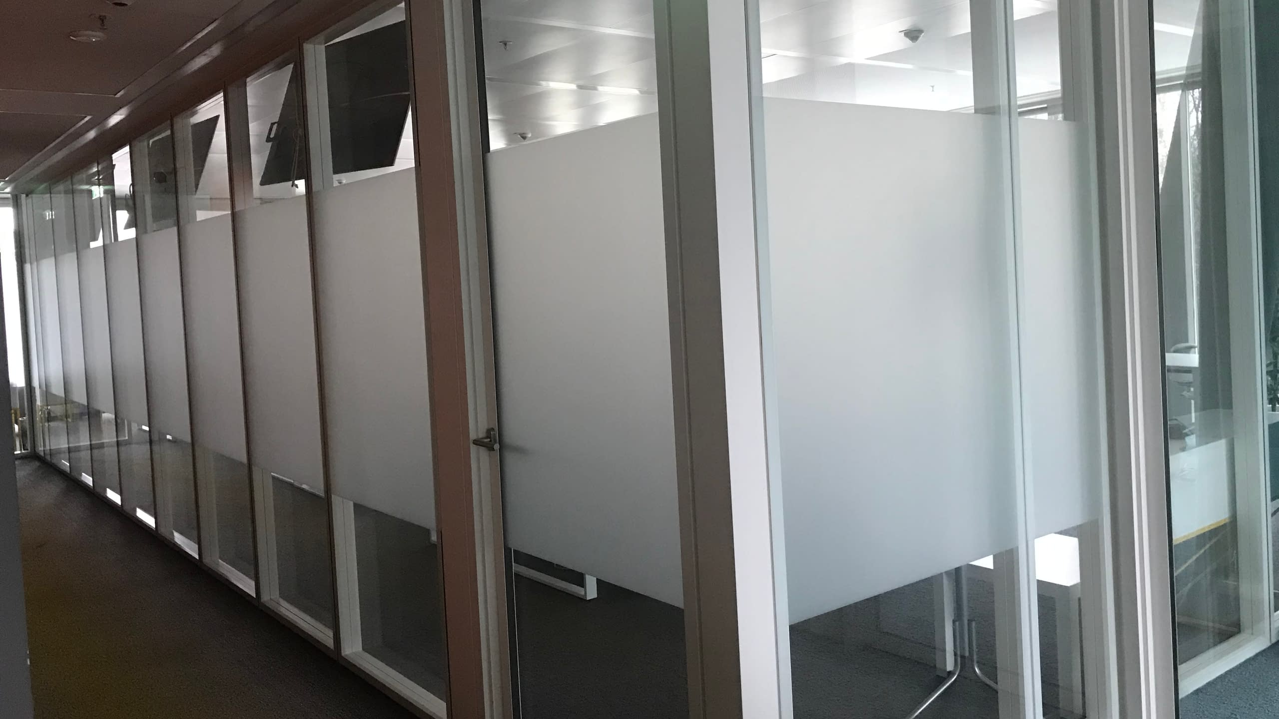 Матиране на стъклени преградни стени в офис в София с пясъкоструйно фолио за осигуряване на дискретност.