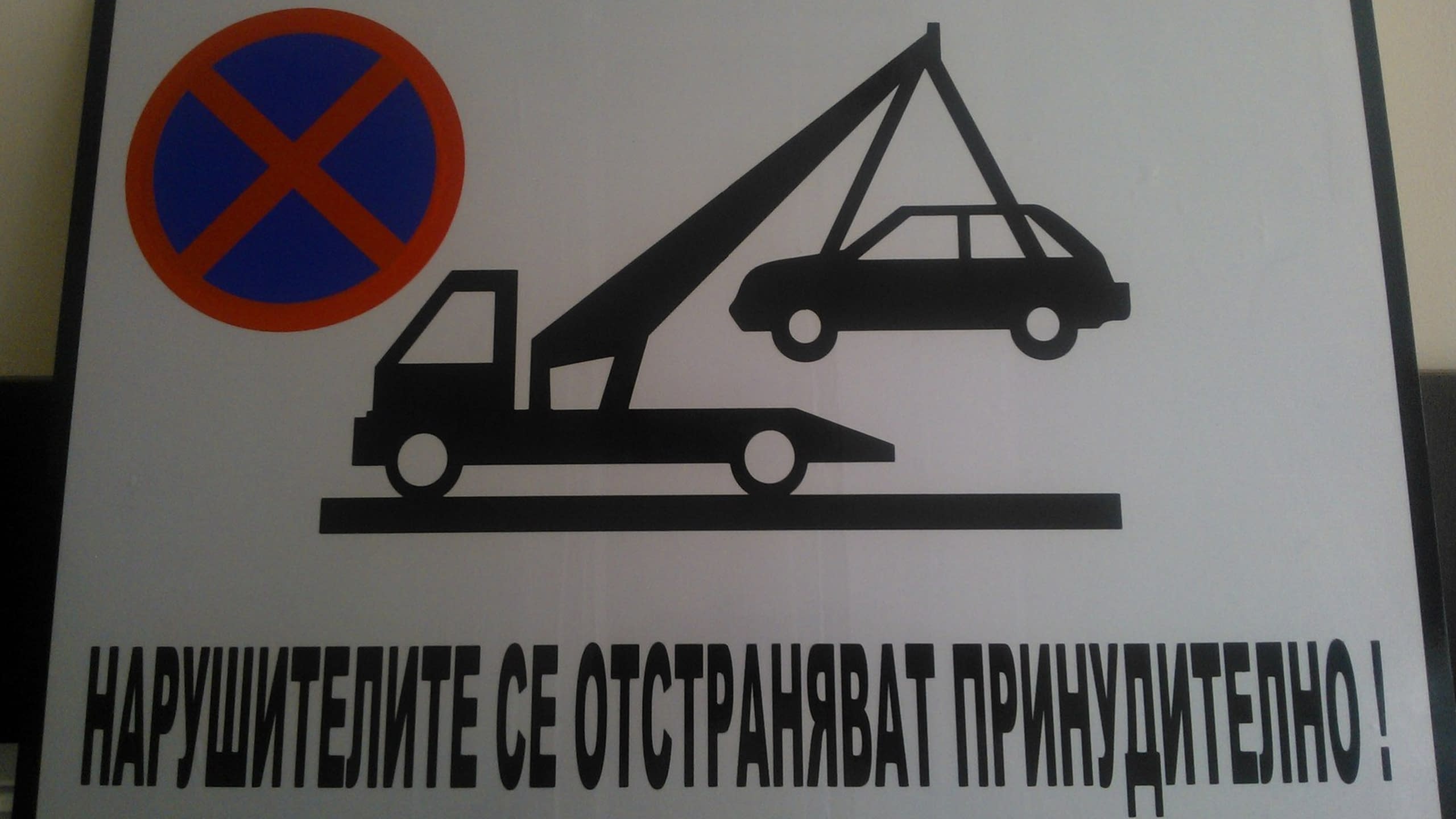 Табела със знаци за забранено паркиране и репатриране с паяк, и предупредителен надпис.