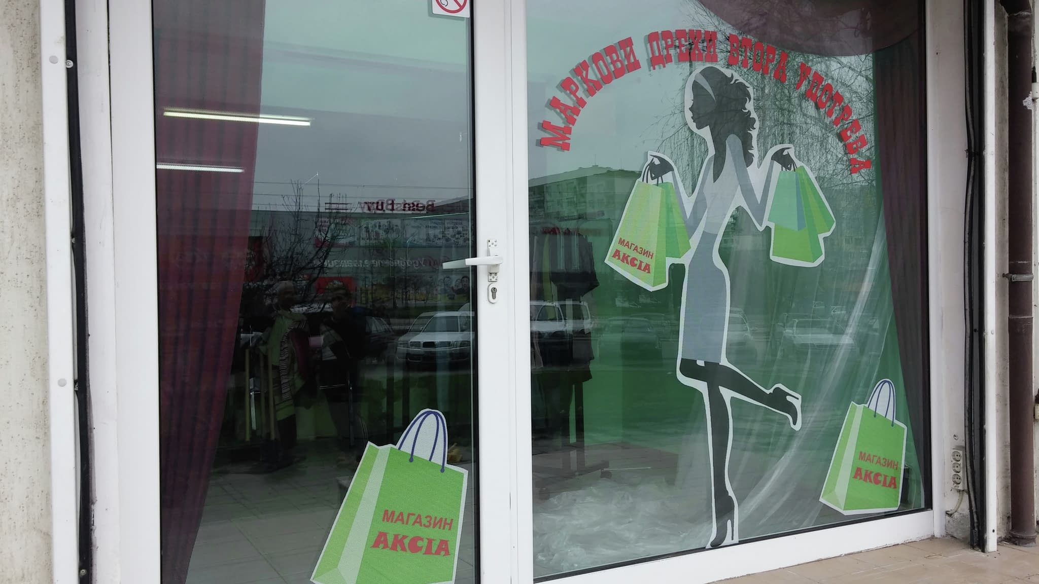 Витрина на магазин със силует на жена с пазарски чанти, червен текст, съобщаващ за разпродажба, и зелени графики с логото ‘Магазин Акция’.