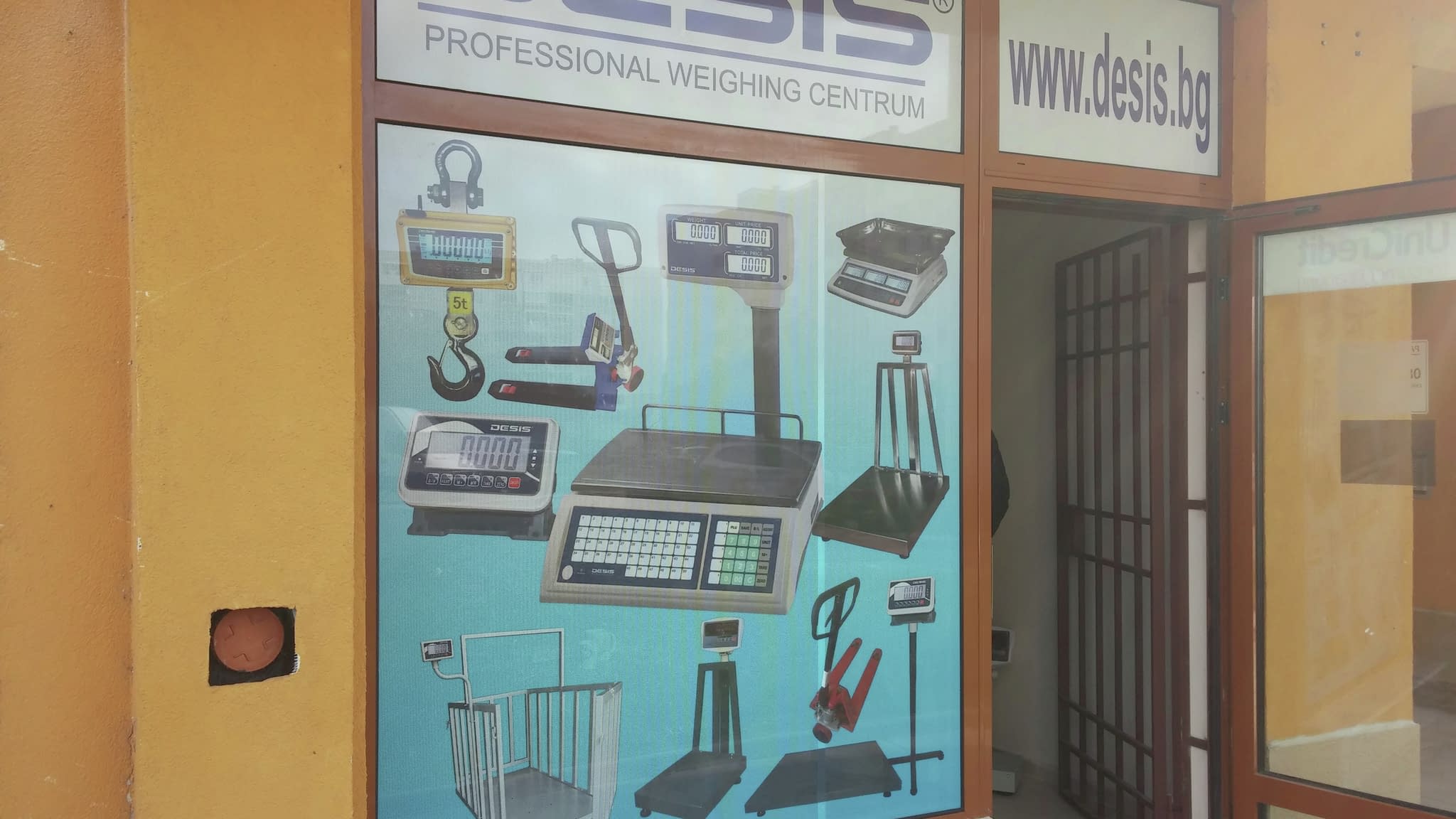 Професионално лепене на перфо фолио върху витрина на „Desis“, демонстриращо качествена изработка и прецизност.