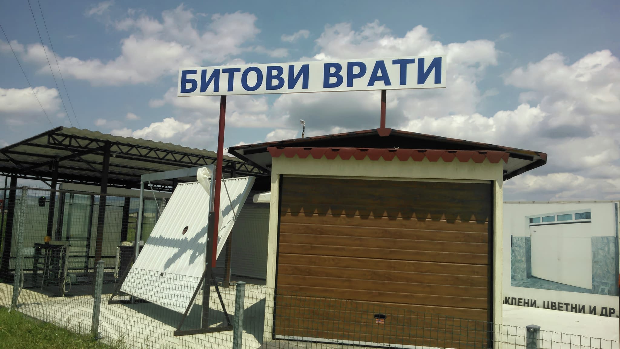 Сграда с надпис „БИТОВИ ВРАТИ“, показваща дървена гаражна врата и демонстрационни конструкции.