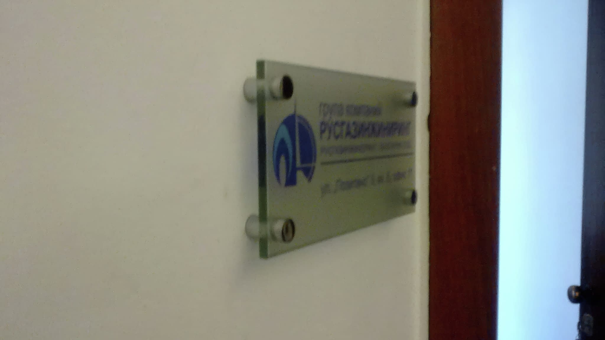 Фирмена табела на офис стена – акрилна табела с метални държачи, създаваща професионален облик и корпоративна идентичност.