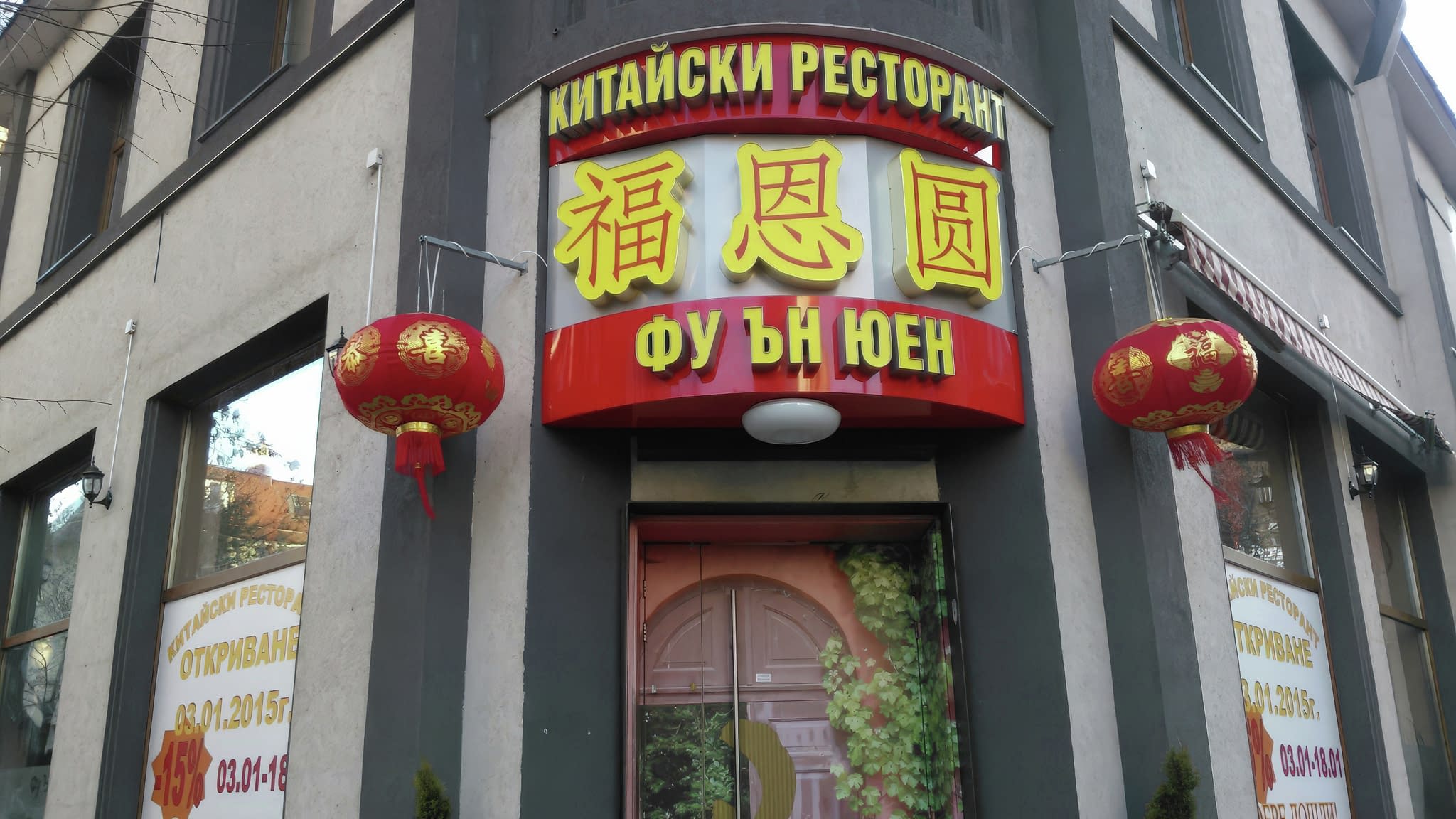 Екстериор на китайски ресторант „Фу Ън Юен“ с червена светеща табела, жълти йероглифи и традиционни червени фенери.