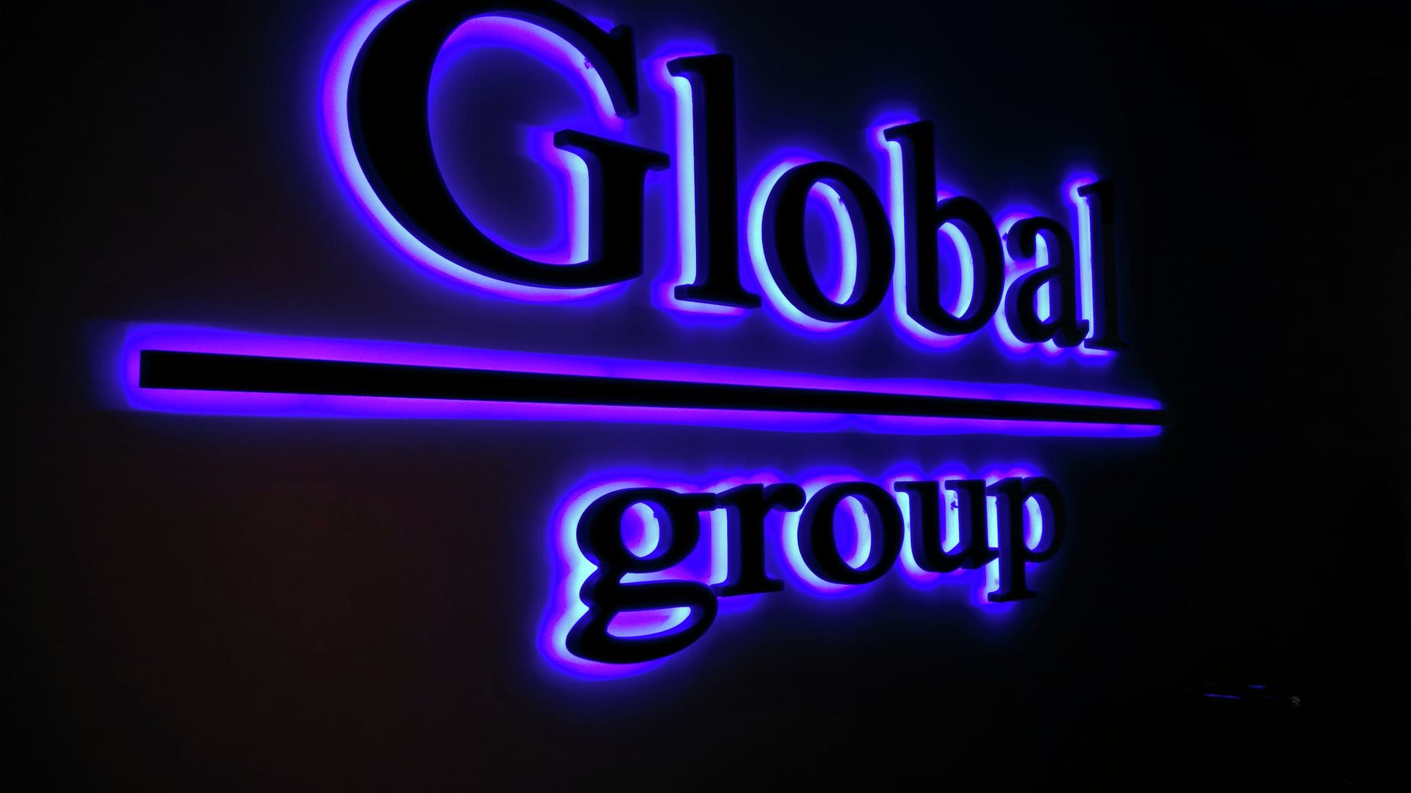 Обемни букви на стена с надпис „Global group“ в удебелен син шрифт – пример за вътрешно офисно брандиране.