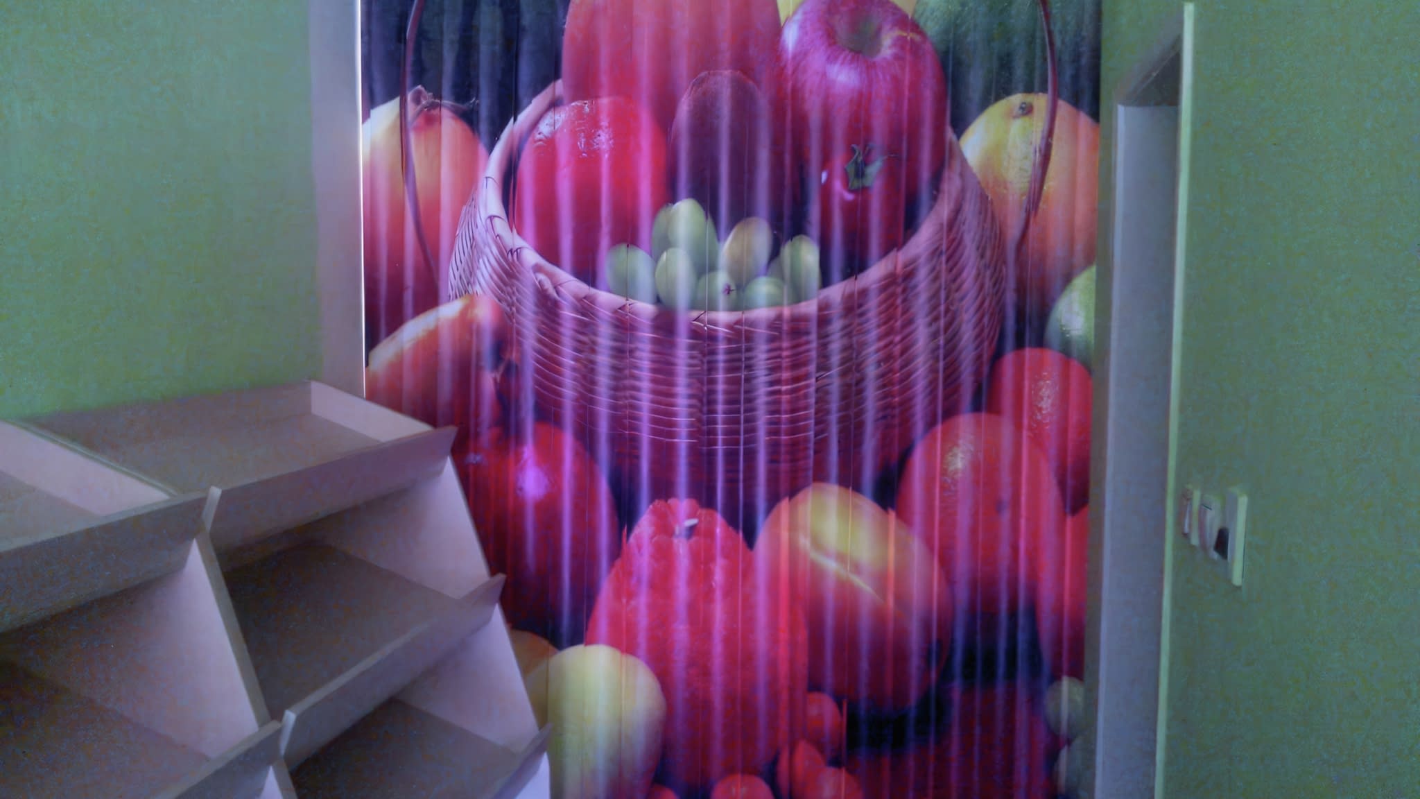 Винилово пано с ярък печат на кошница, пълна с ябълки, грозде, портокали и други плодове, поставено в търговско помещение.