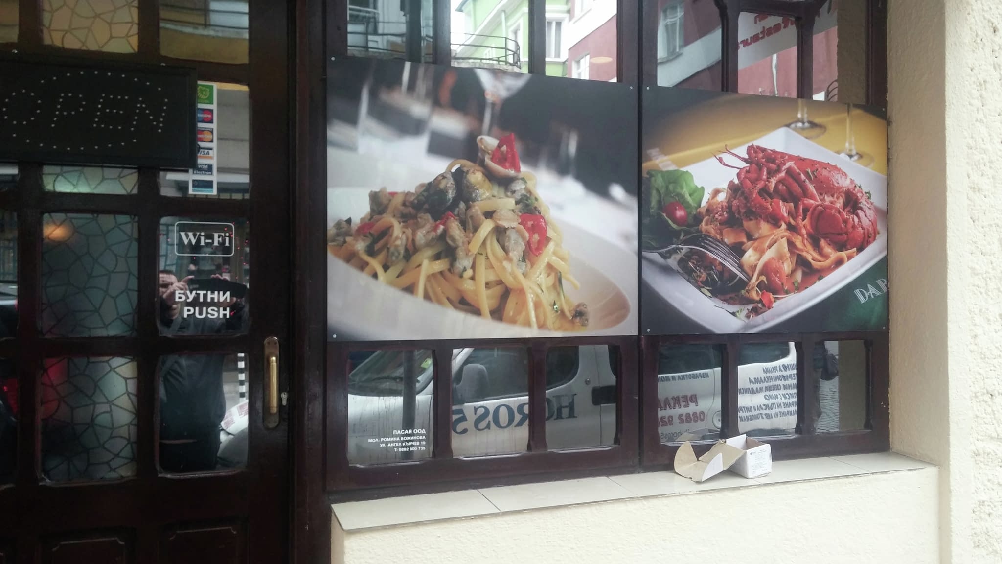Две рекламни снимки на витрина – паста с морски дарове, гарнирана със зеленчуци, и паста с омар, поднесена със свежи билки.
