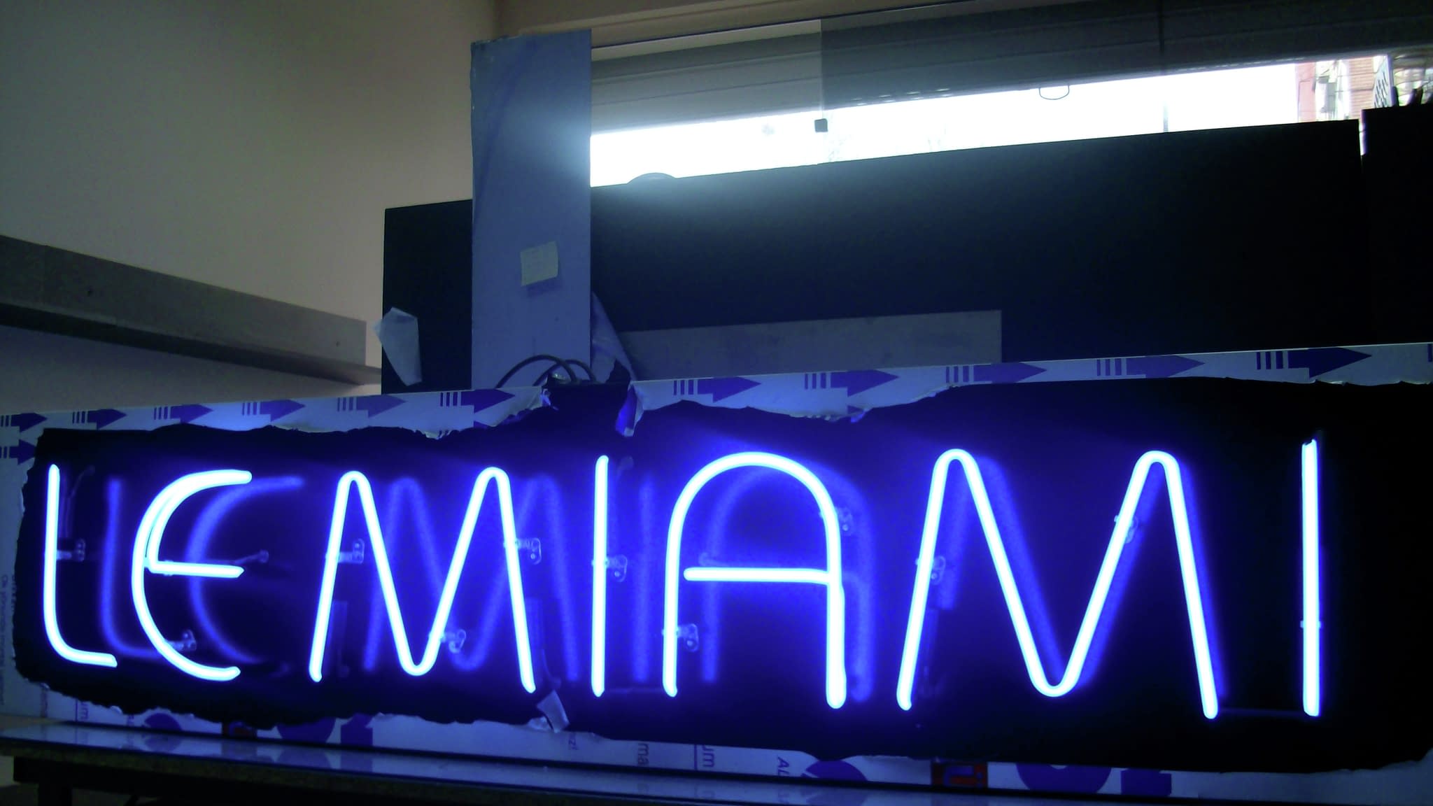 Ярък син неонов надпис „LE MIAMI” – за барове и нощни клубове.