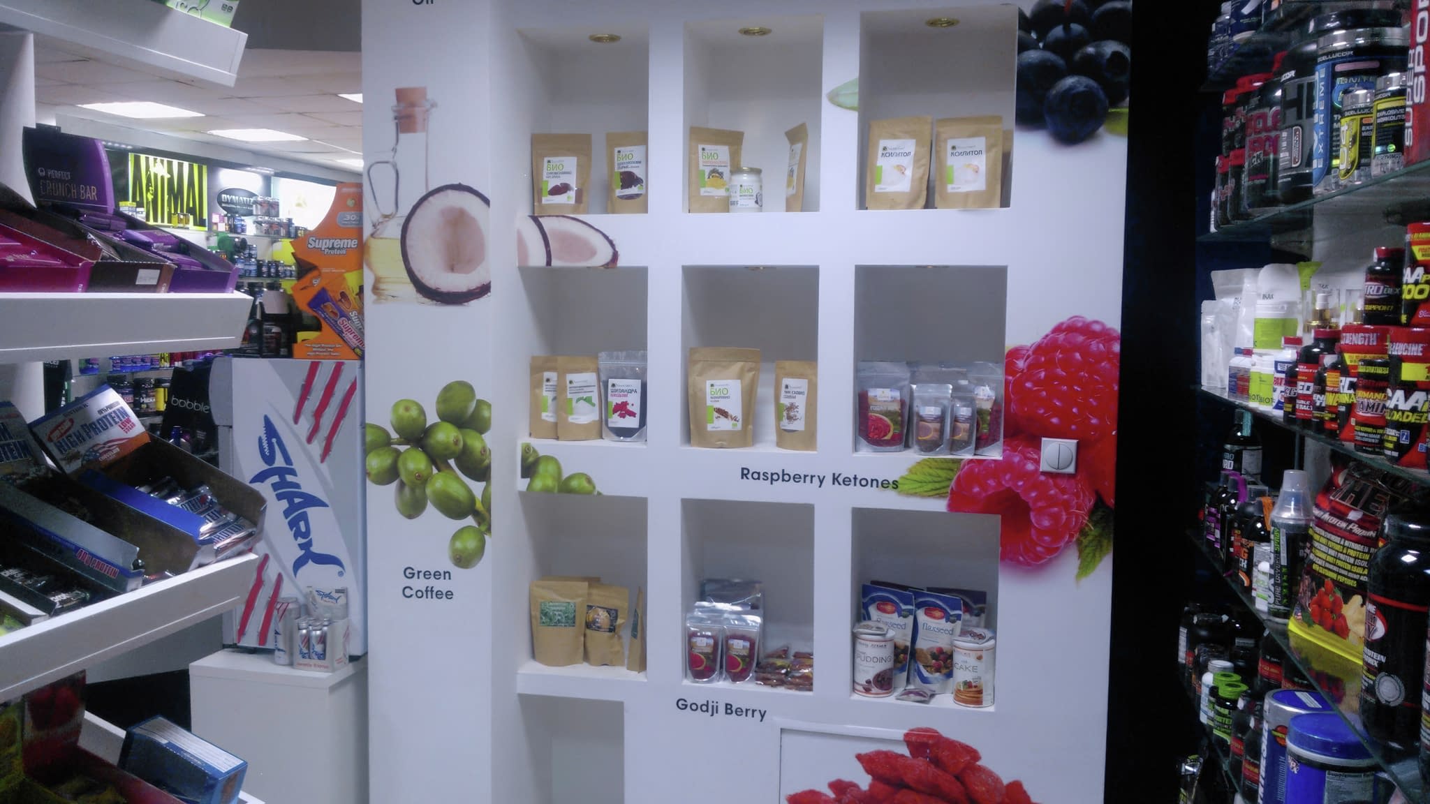 Рекламни лепенки за магазин – стилна стена с брандирани ниши, изобразяващи здравословни продукти като кокосово масло, зелено кафе, акай бери, малинови кетони и годжи бери.