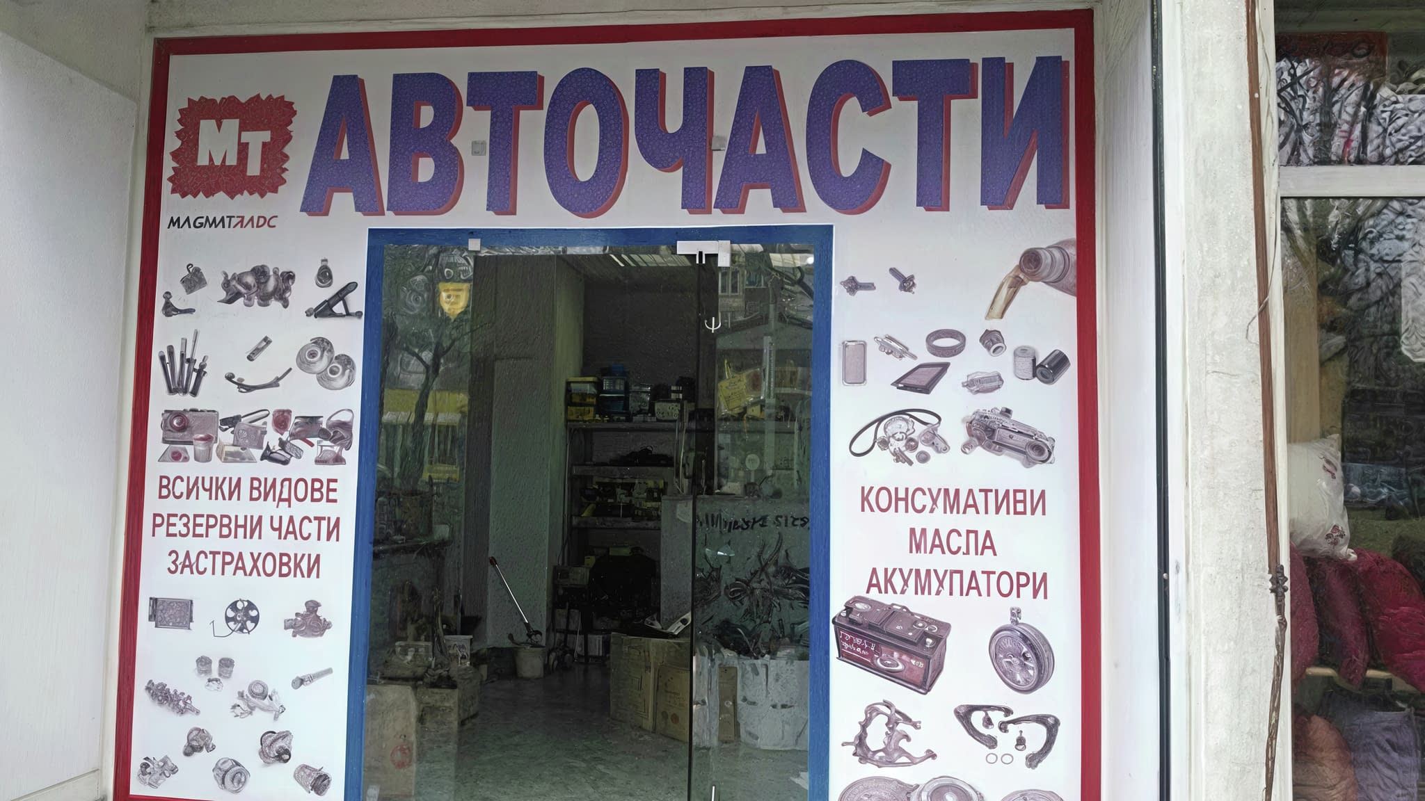 Фасада на магазин за авточасти с надписи от фолио, представящи услуги като резервни части, масла и акумулатори.