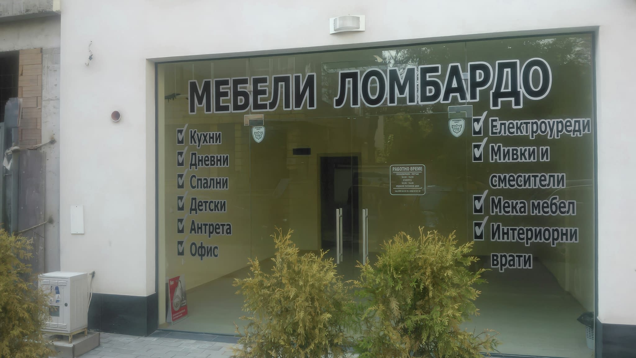 Стикери за витрини на магазин 'Мебели Ломбардо' – стилно брандиране с ясно изписани категории продукти като кухни, дневни, спални и офис мебели.