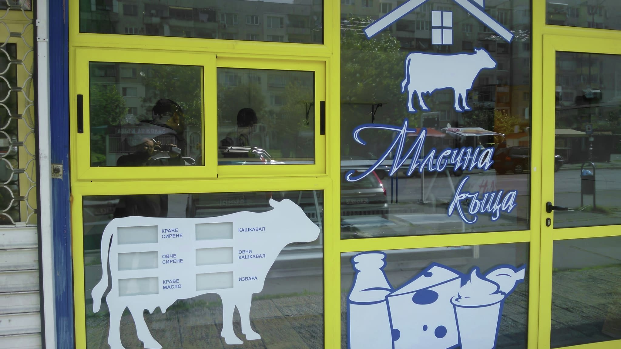 Оформена витрина на млечна къща с лого и илюстрации на млечни продукти със запомнящ се облик.