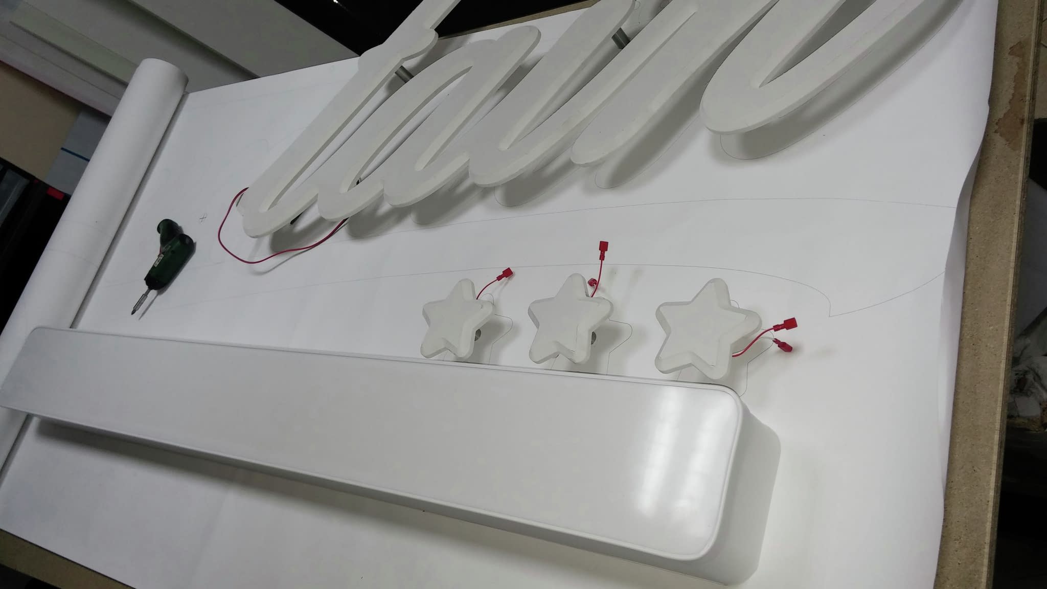 Подготовка на светеща табела – работилница с LED осветление и изрязани букви за рекламна табела преди монтаж.