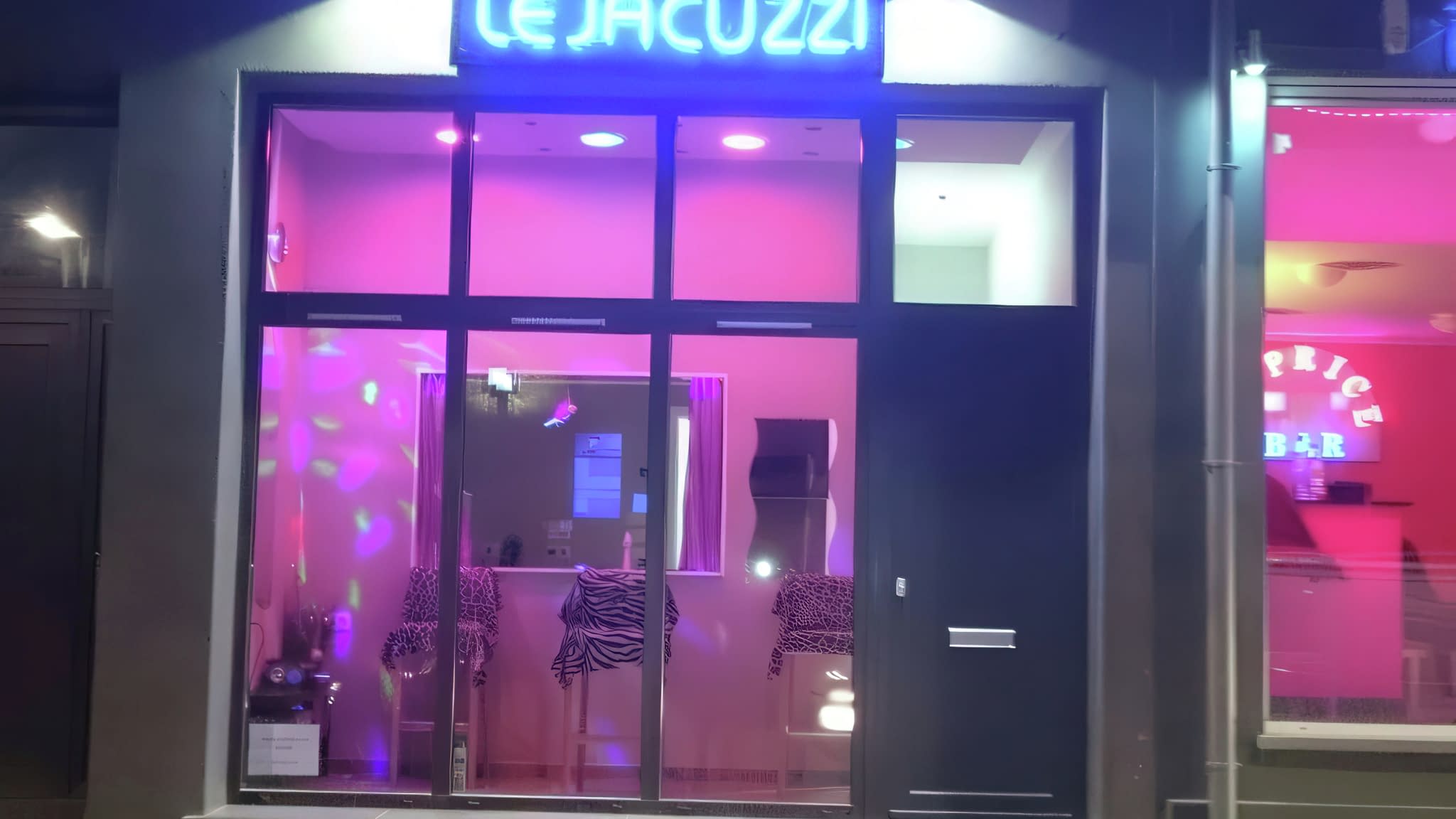 Светеща неонова табела с надпис ‘Le Jacuzzi’ – атрактивна фасадна реклама с розова подсветка.