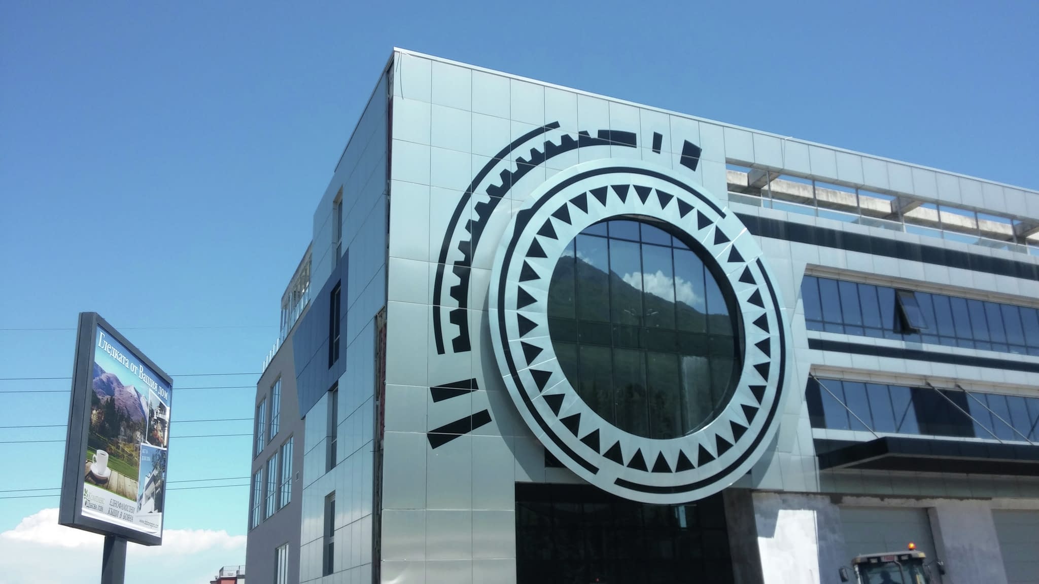 Фасада на бизнес сграда с кръгла декоративна табела – модерен архитектурен елемент за корпоративна идентичност.