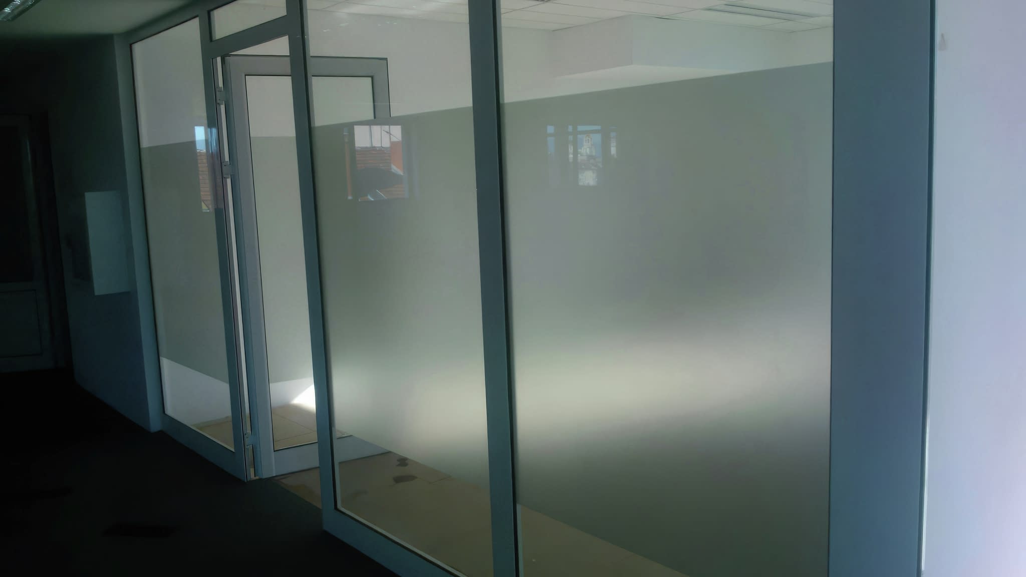 Стъклени прегради с фолио, осигуряващо уединение в офиса.