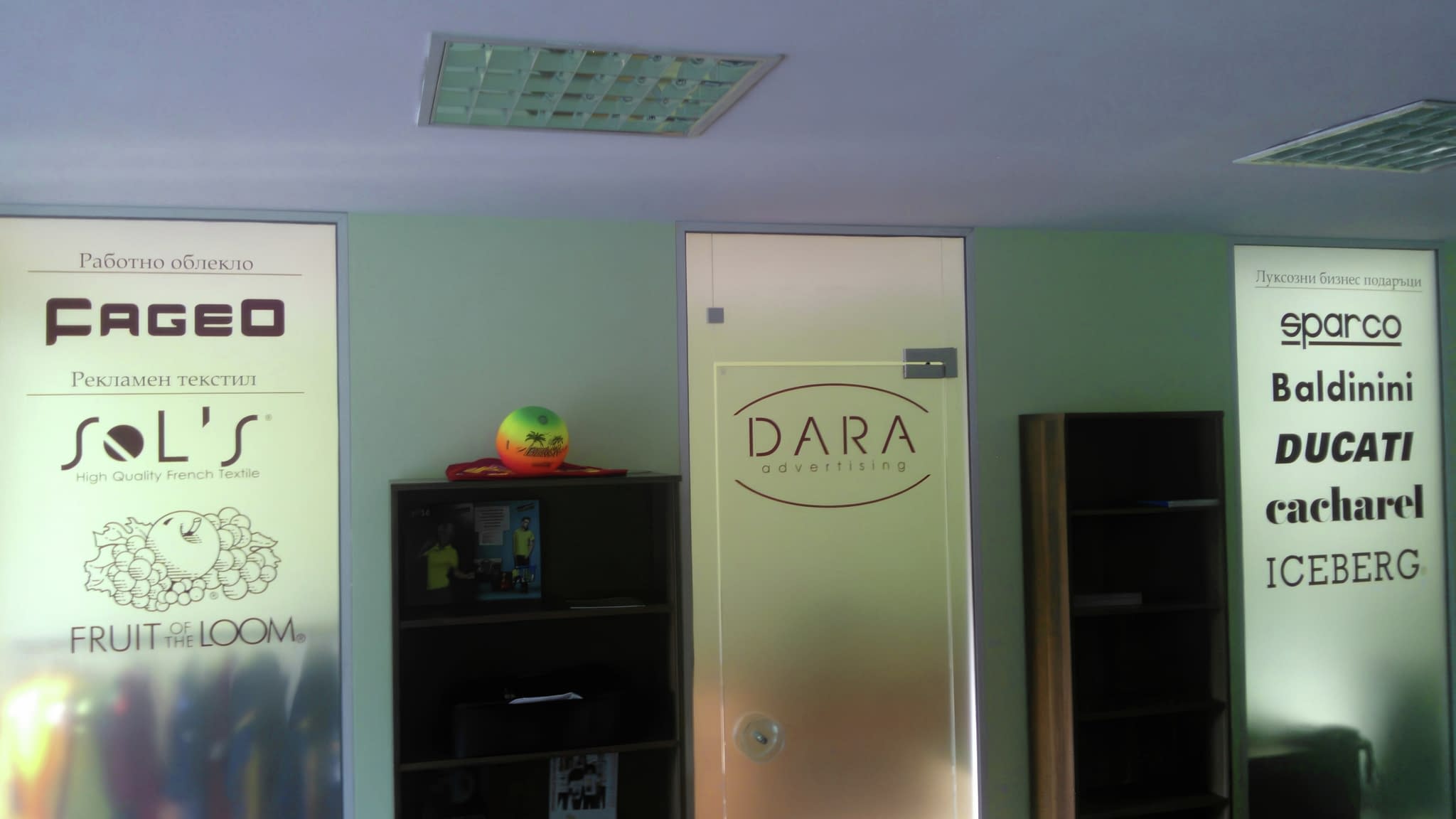 Рекламно фолио за прозорци с матиран ефект и фирмено лого в офис пространство.