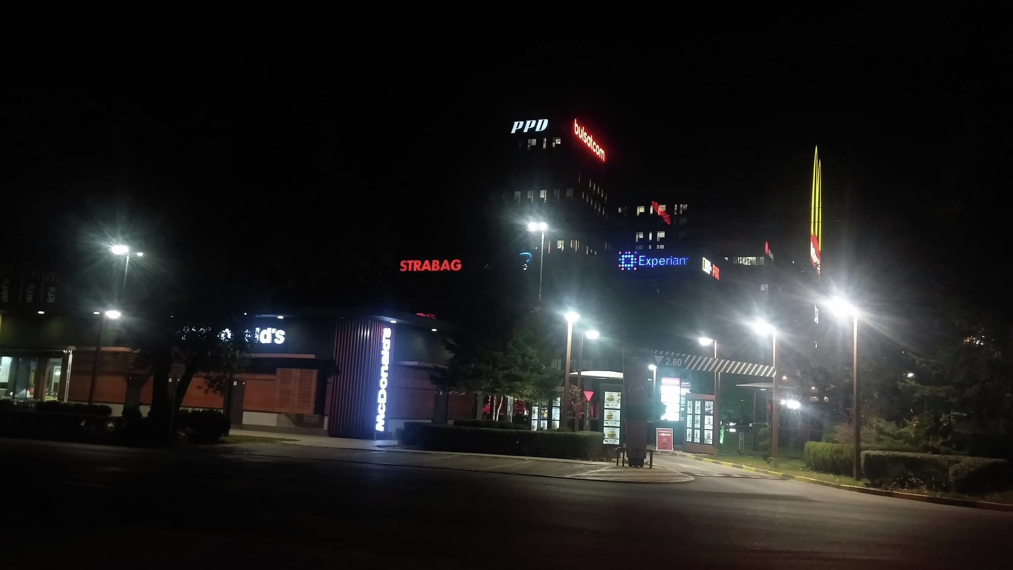 Нощен изглед на сграда с осветени фирмени лога и светещи букви – LED реклама за офиси и търговски обекти.