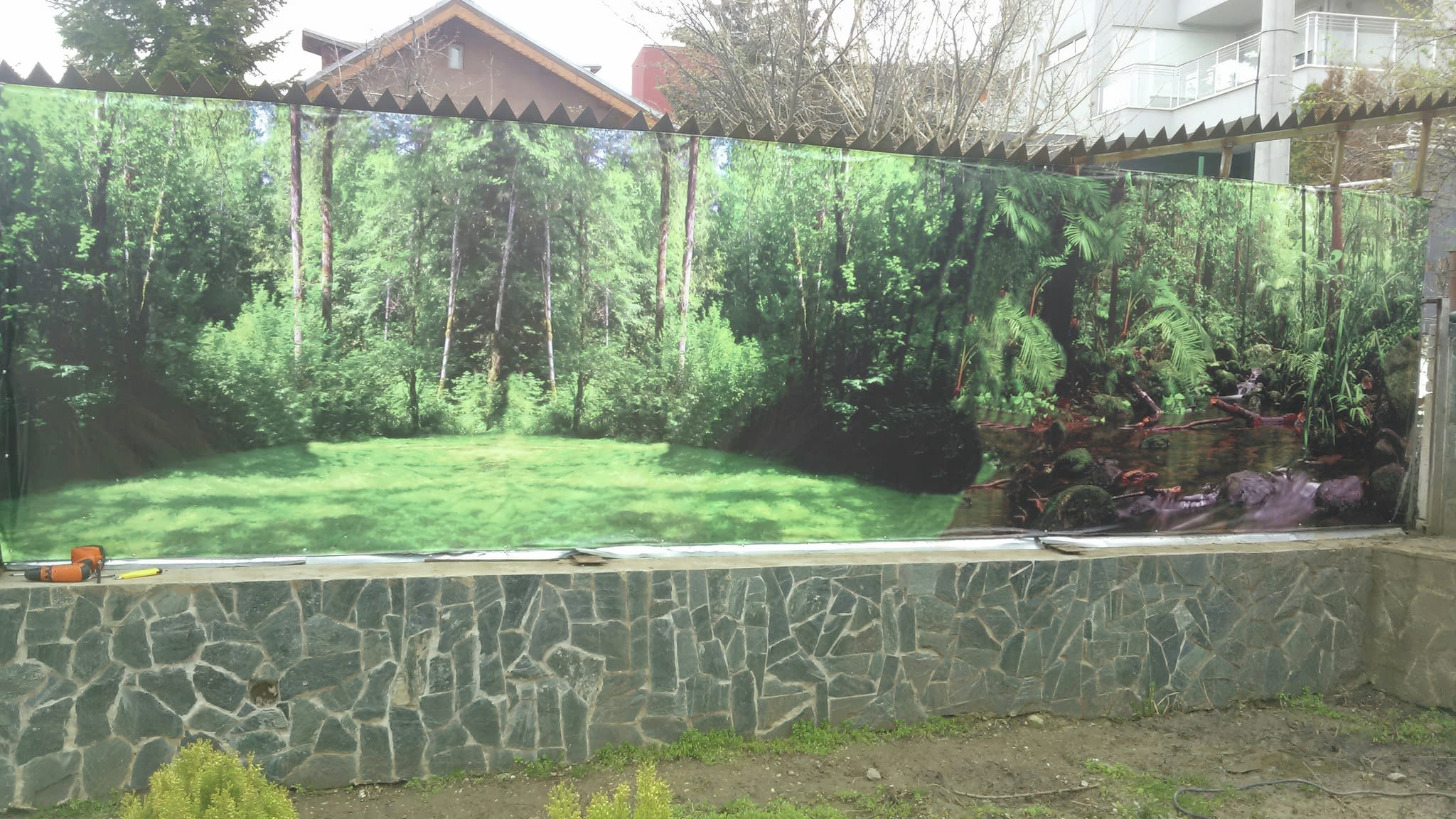 Пълноцветно рекламно пано с горски пейзаж, отпечатано върху винил и монтирано на външна ограда.