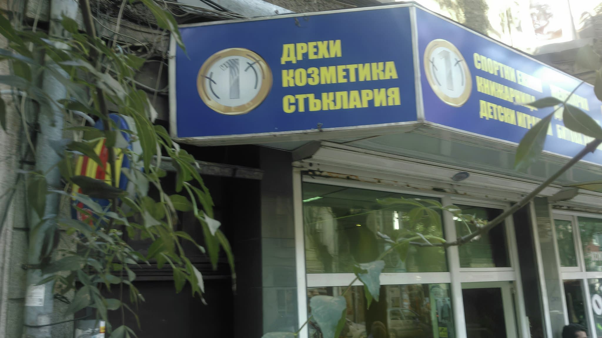 Светеща табела със син фон и надпис 'Дрехи, козметика, стъклария' – пример за стилно брандиране на магазин с LED осветление.