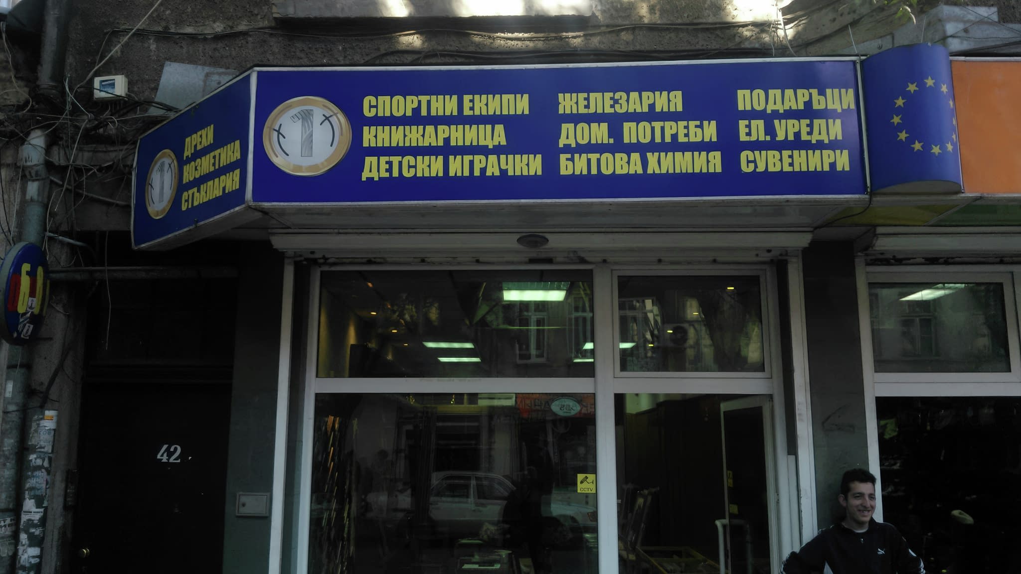 Светеща табела над витрина с рекламен надпис за спортни екипи, книжарница, детски играчки и домакински стоки – ефективна LED реклама за магазини.