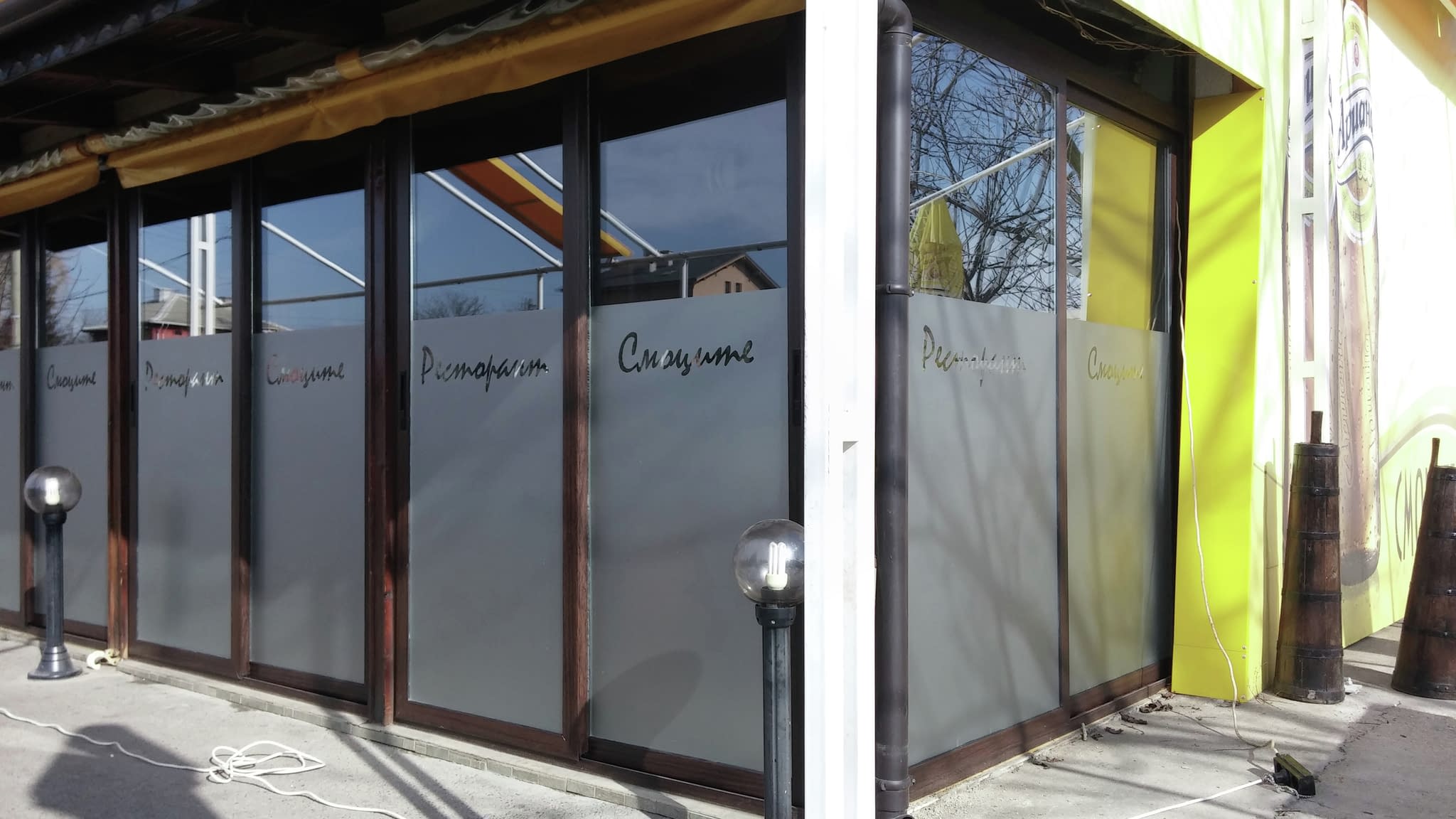 Ресторант „Смоките“ с ярка жълта фасада и матирани стъкла, създаващи уютна и дискретна атмосфера.