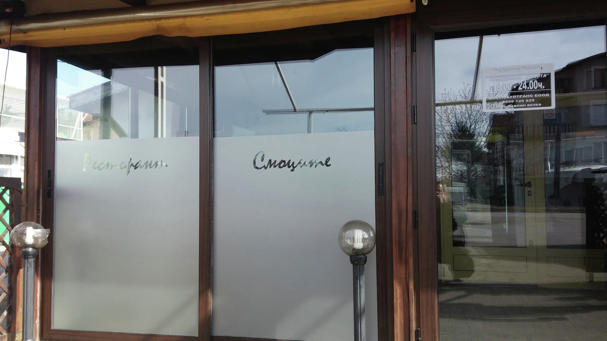 Вход на ресторант с двукрила врата с матирано стъкло, подчертаваща дискретността и модерния стил.