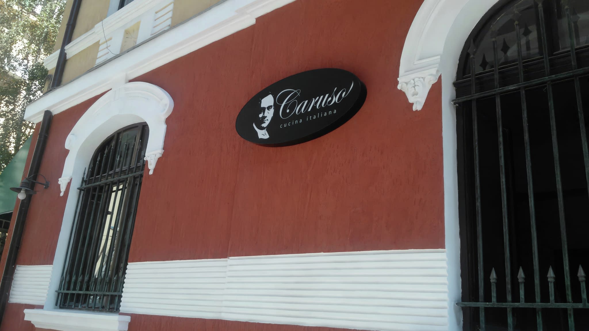 Светлинна реклама на ресторант 'Caruso' с елегантна овална LED табела – стилно и енергийно ефективно външно брандиране.