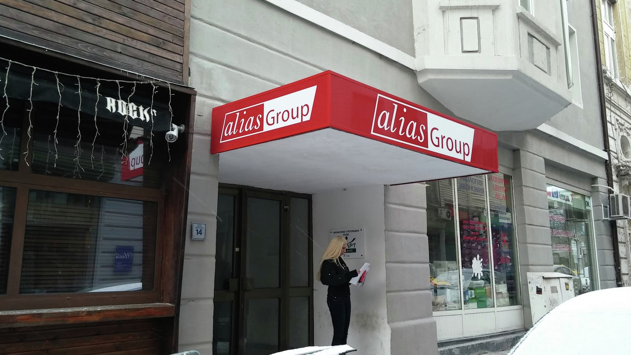 Информационна табела за офис с фирмено лого и ярък червен цвят – подходяща за сгради с административни и търговски обекти.