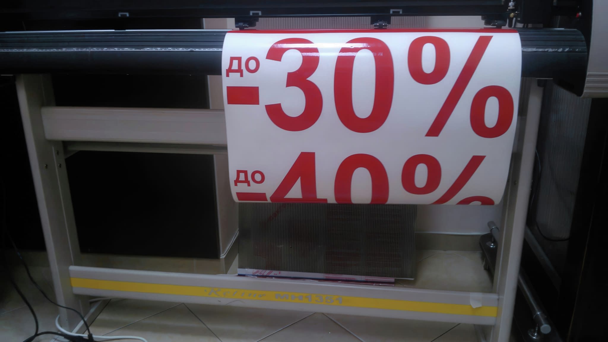 Плотер, който изрязва рекламно фолио с надпис „до -30%“ и „до -40%“ в червен цвят.