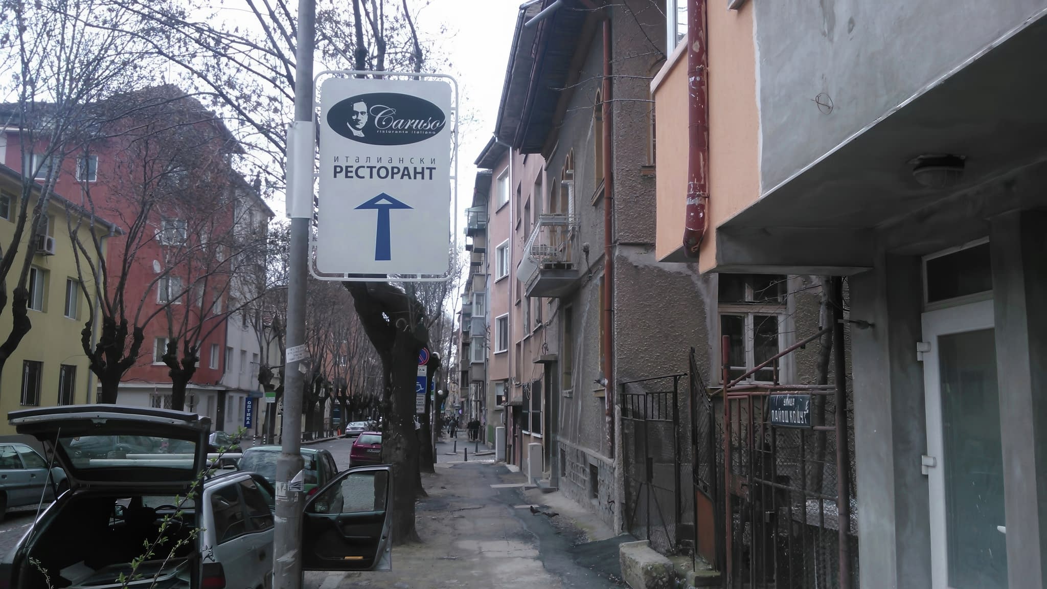 Улична указателна табела за ресторант – информационен знак на стълб, осигуряващ лесна ориентация за пешеходци и автомобилисти.