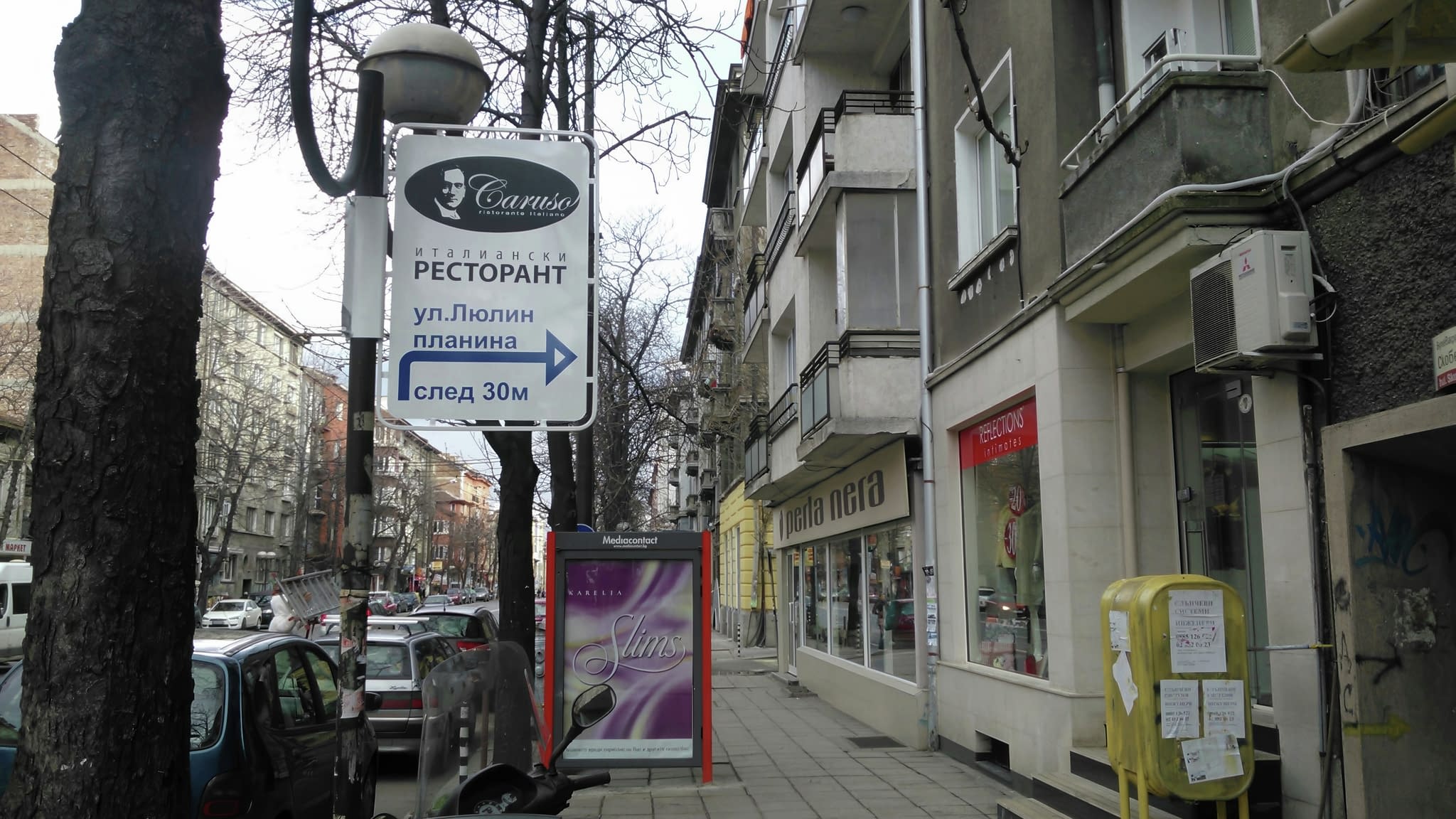 Указателна информационна табела за ресторант, монтирана на стълб – насочваща табела за търговски обекти в градска среда.