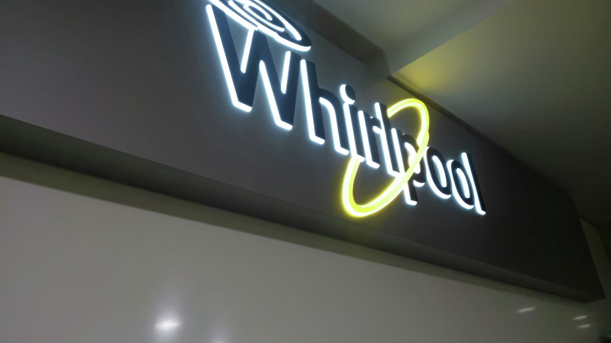 Осветено лого на Whirlpool в близък план с обемни букви и LED контур.