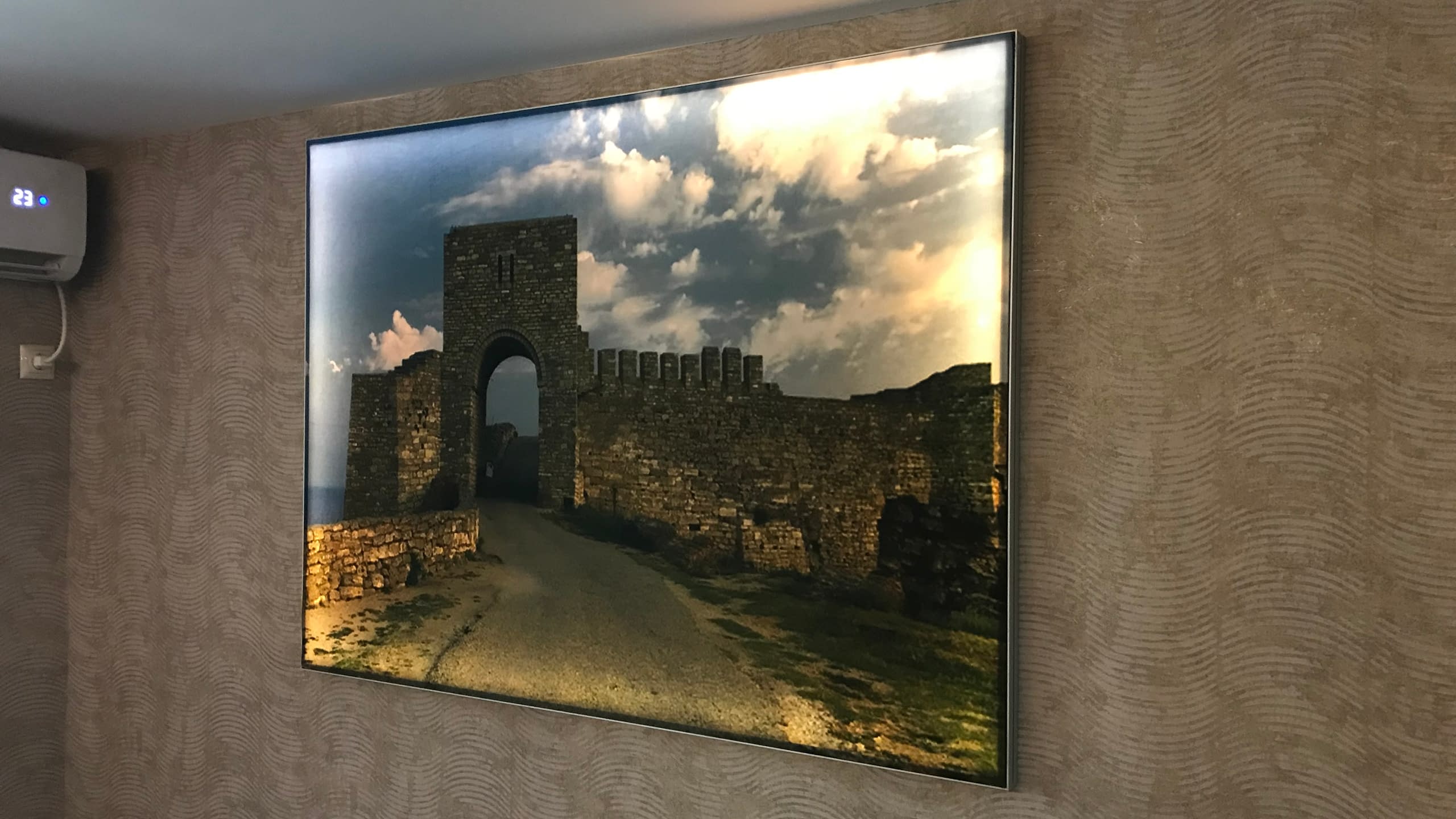 Интериорна светеща картина с текстилно платно и пълноцветен печат, изобразяваща пейзаж с крепостна стена, монтирана на стена.