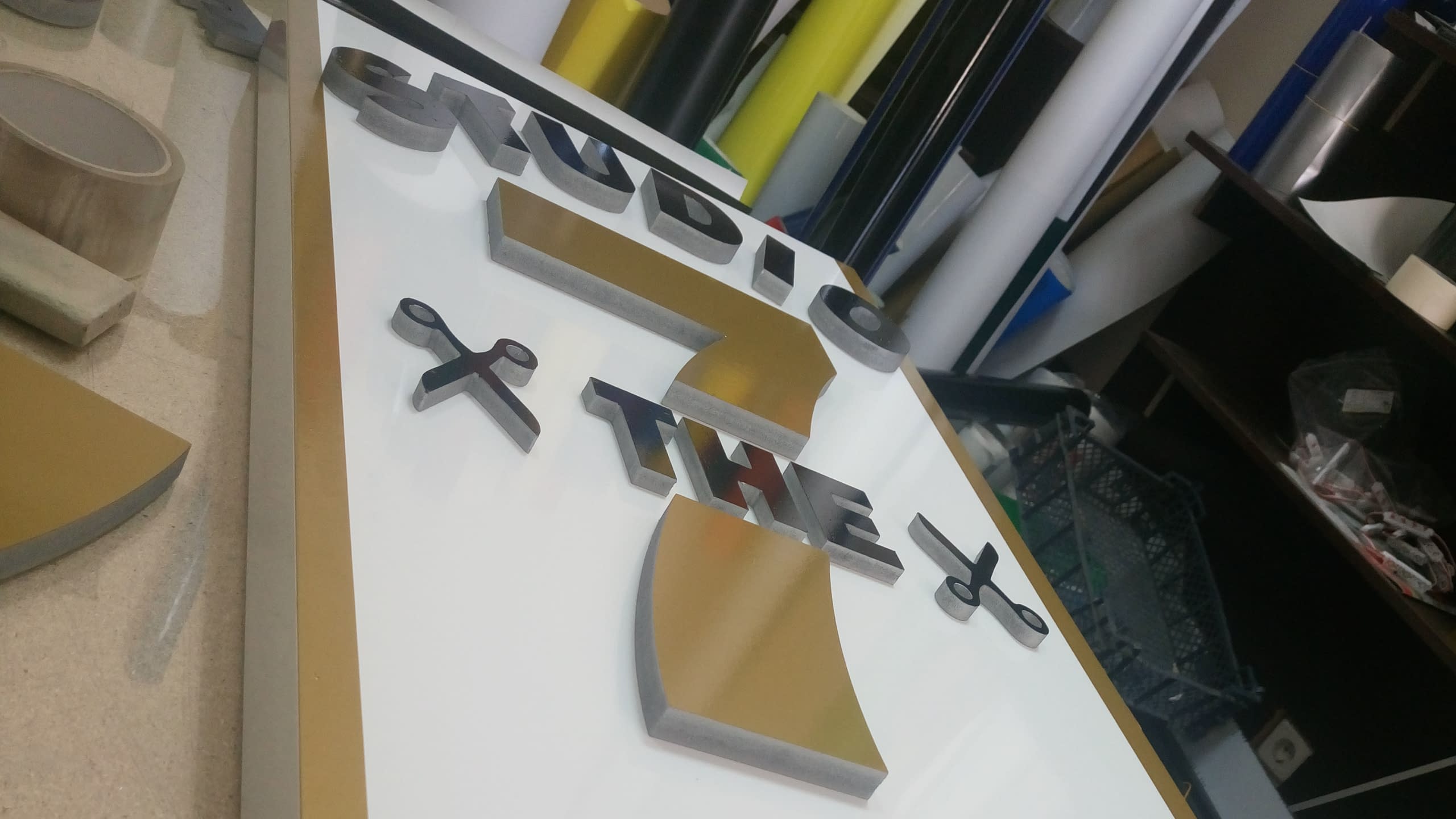 Табела за фризьорски салон "Studio THE 7" в процес на изработка с обемни букви със златист и сребрист ефект.